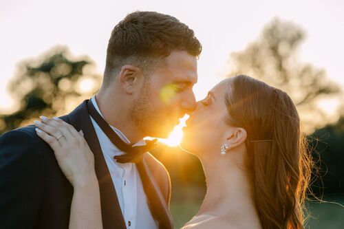 Baiser des mariés au coucher du soleil