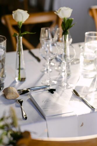 Détails de la table de mariage avec roses blanches et verrerie