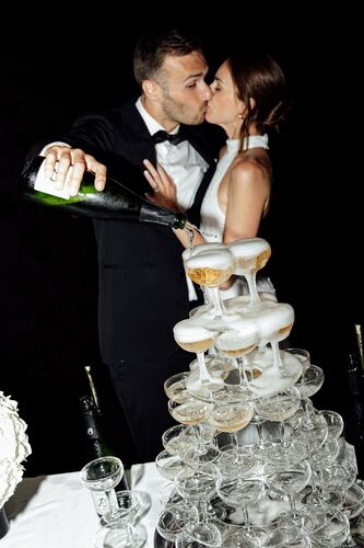 Mariés versant du champagne dans une fontaine de coupes