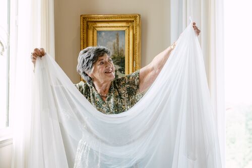 Grand-mère de la mariée tenant son voile pendant les préparatifs