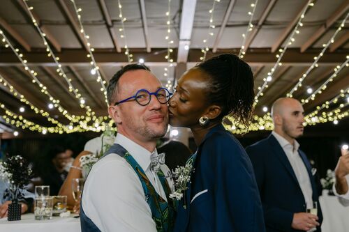 Invités profitant du cocktail de mariage sous les guirlandes lumineuses