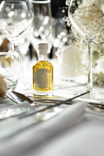 Détail de la table de réception avec fleurs et verrerie et huile du Domaine